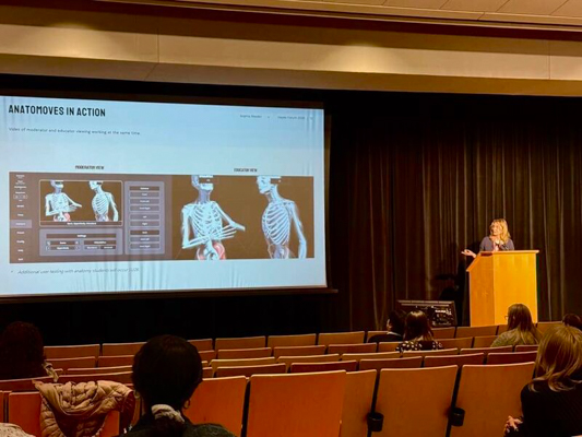 Blonde woman stands at a podium presenting
