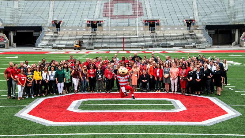 Image of conference attendees with Brutus Buckeye on the 50-yard line of Ohio Stadium
