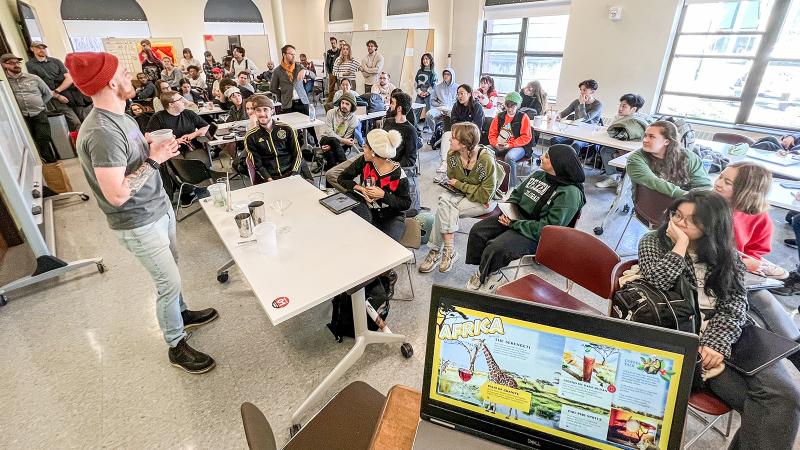 A mixologist presents to a room filled with students.