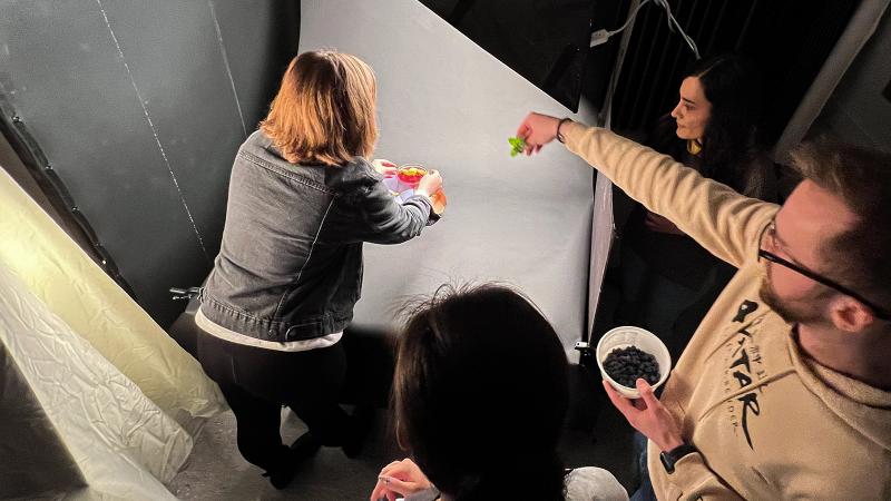 Four students arrange a mocktail drink in a photo studio.