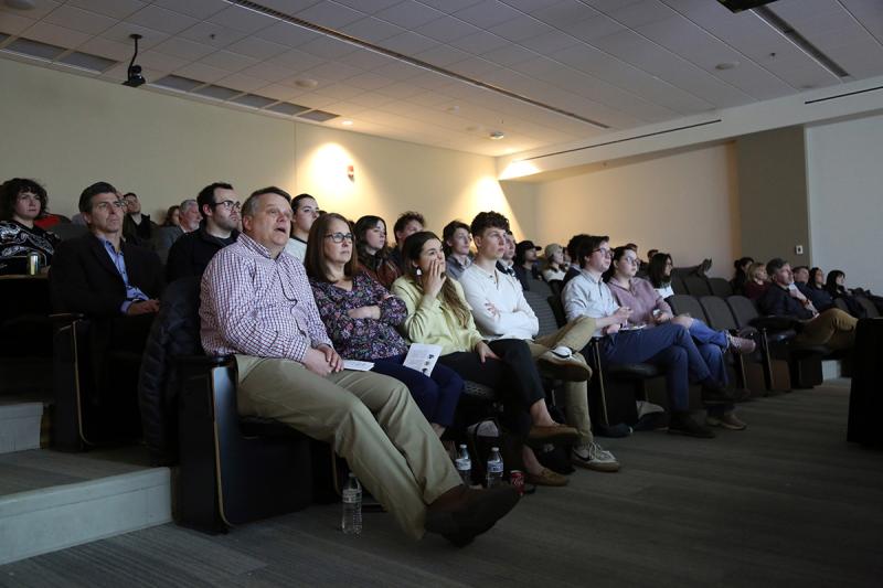 crowd of people sitting in theater seats in a dark room
