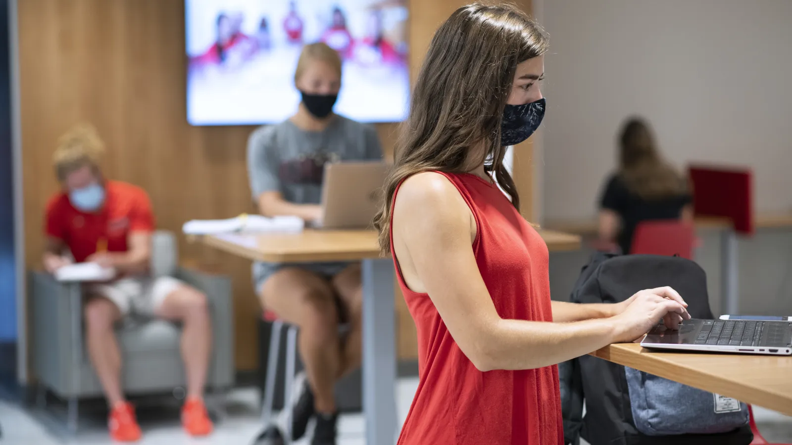 Students on computers physically distanced and wearing masks