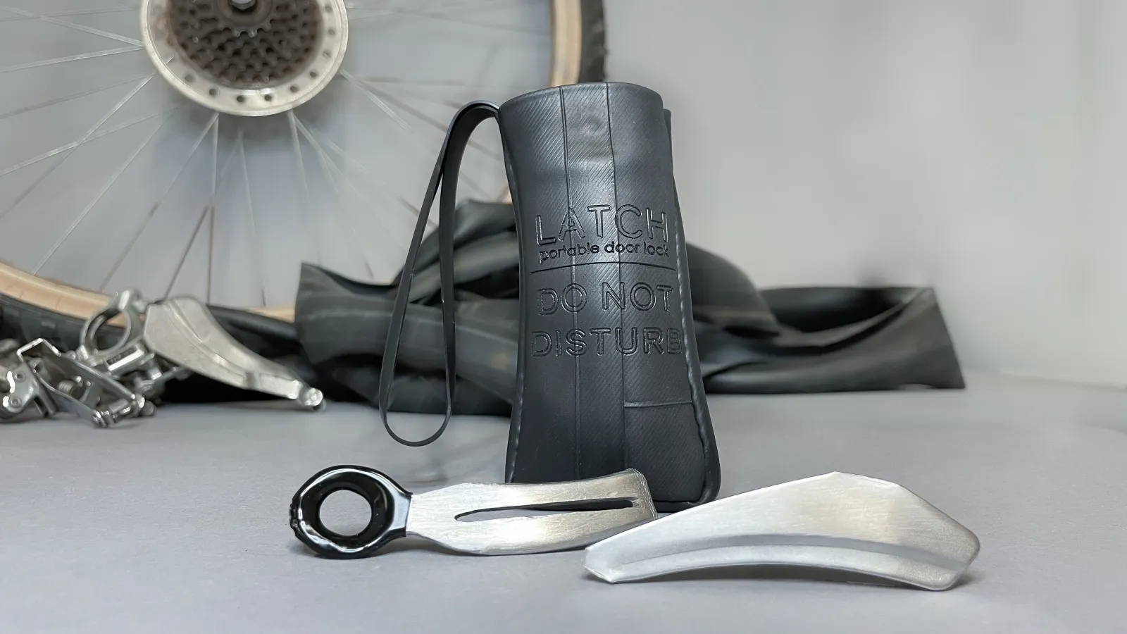 a handcrafted door lock made from bike parts, shown on table in front of bike parts