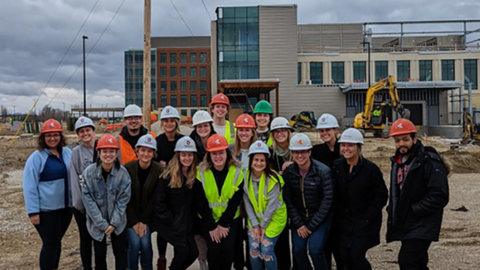 Students pose in front of Wexner Medical Center Outpatient Care Dublin construction site. 