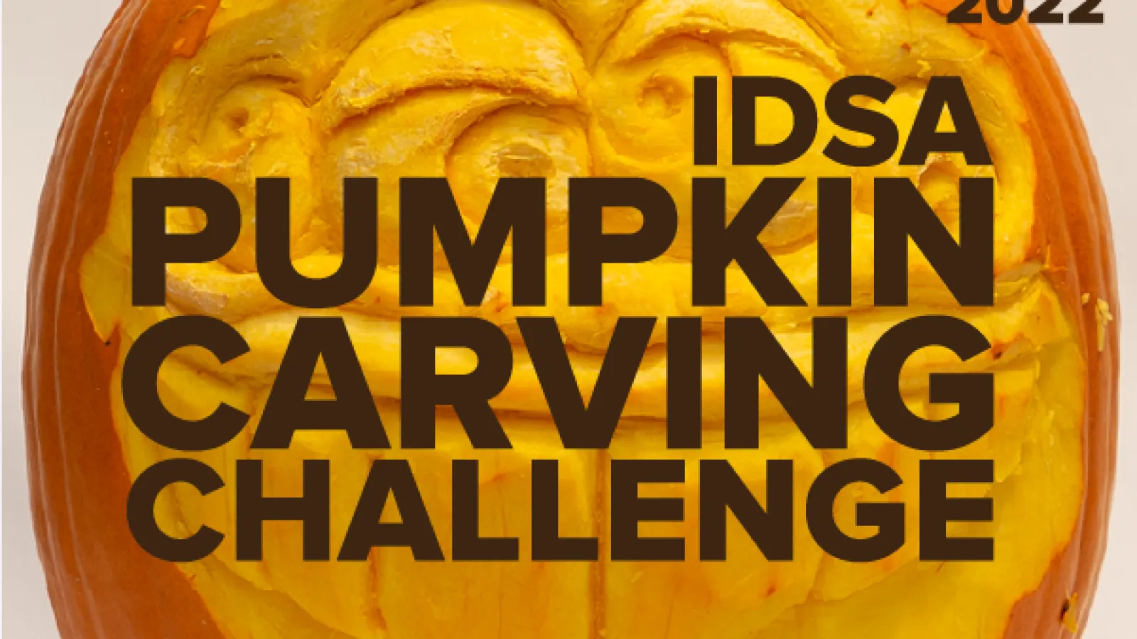 “2022 IDSA Pumpkin Carving Challenge” over a photo of a face carved into a pumpkin.