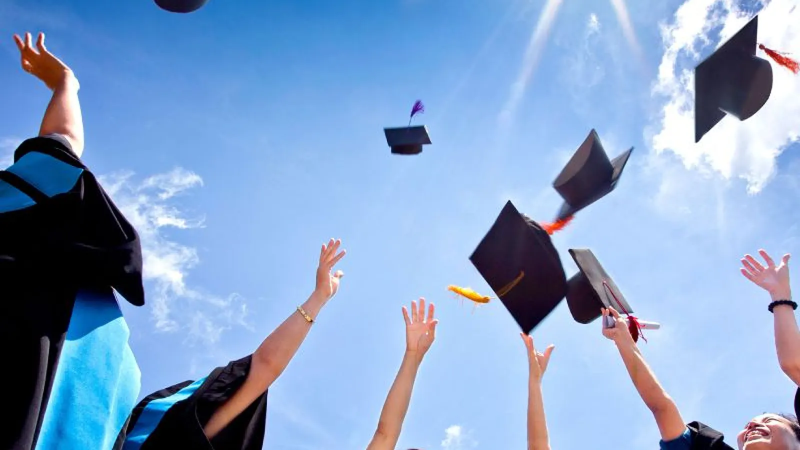 Stock image of student through graduation caps into air. 