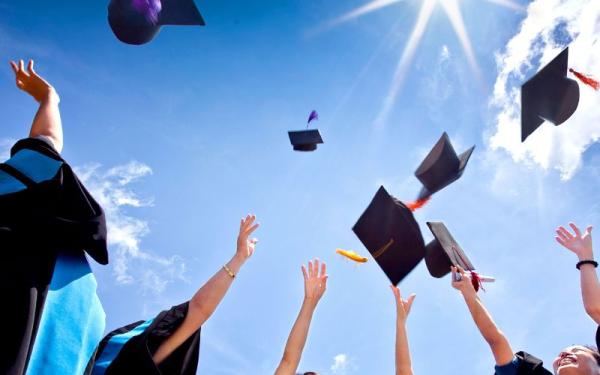 Stock image of student through graduation caps into air. 