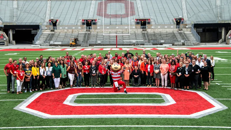 Image of conference attendees with Brutus Buckeye on the 50-yard line of Ohio Stadium