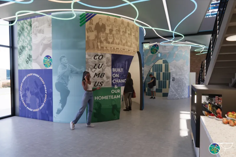 Curved restroom walls that sport a bold graphic with blues, green, and oranges among pictures of people being active divided into a grid like pattern with overlaid graphic expressions. Interweaving colorful neon jogs on the ceiling above. 