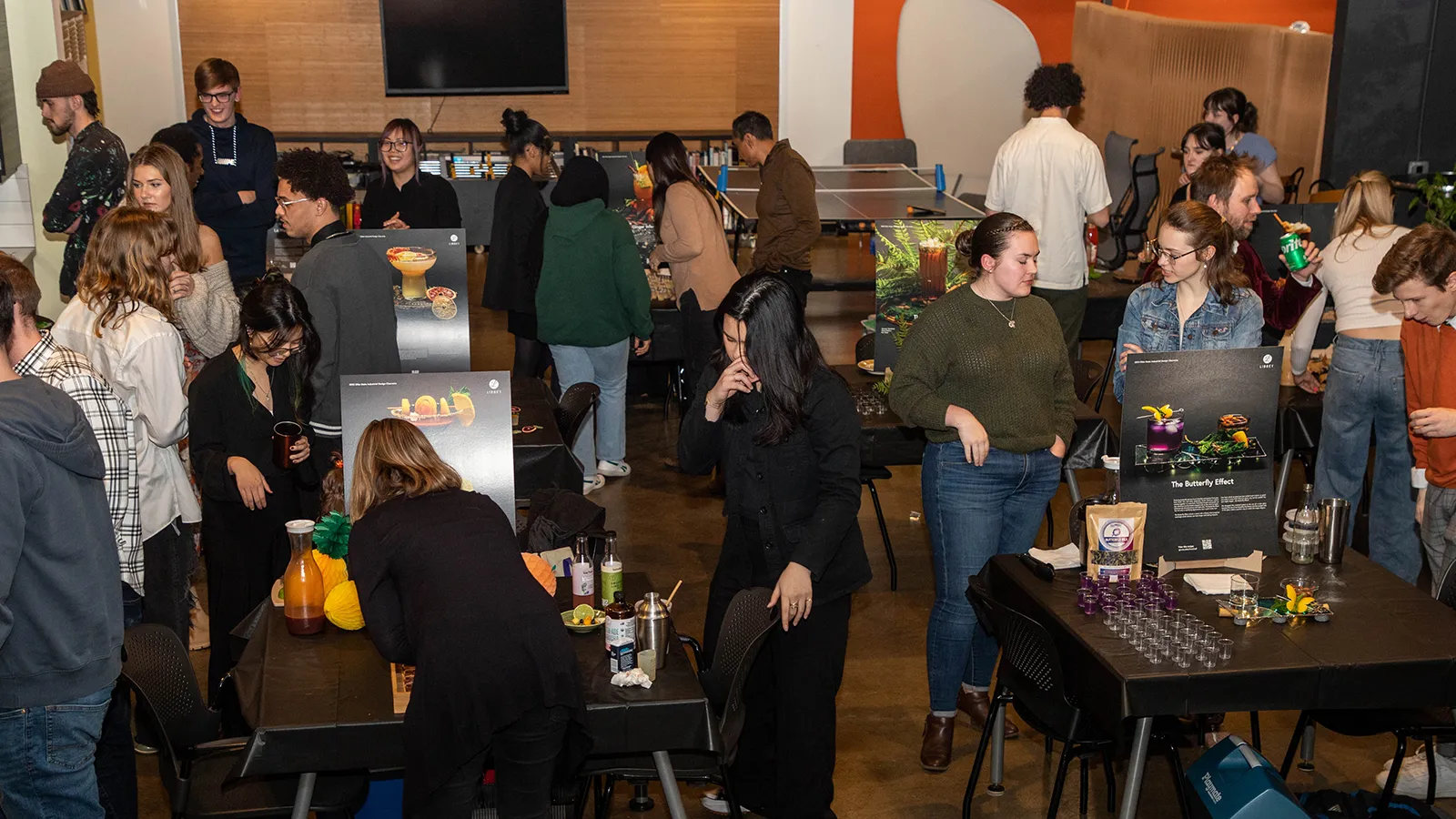 Students and designers walk around a space set up to exhibit mocktail drinks at Priority Designs.