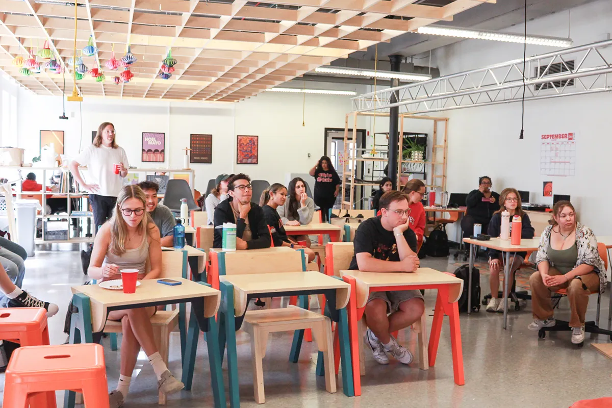 Photo of students sitting at desks watching a presentation in a classroom.