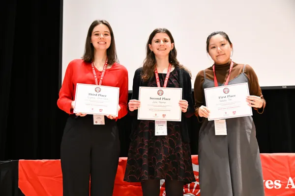 Three woman stand holding award certificates