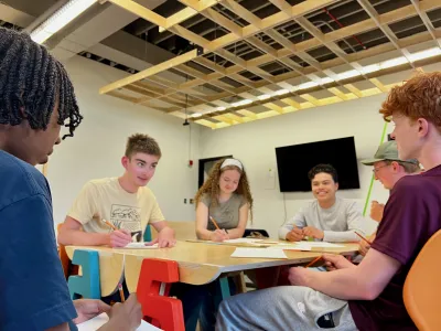 Students gathered around a table collaborating on a design project.