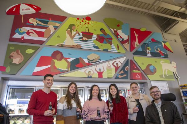 1. Image of 6 students underneath the mural