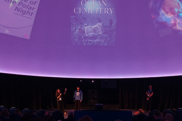 Students speak on planetarium stage.