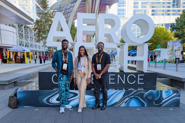 Students stand infront of AfroTech Conference sign
