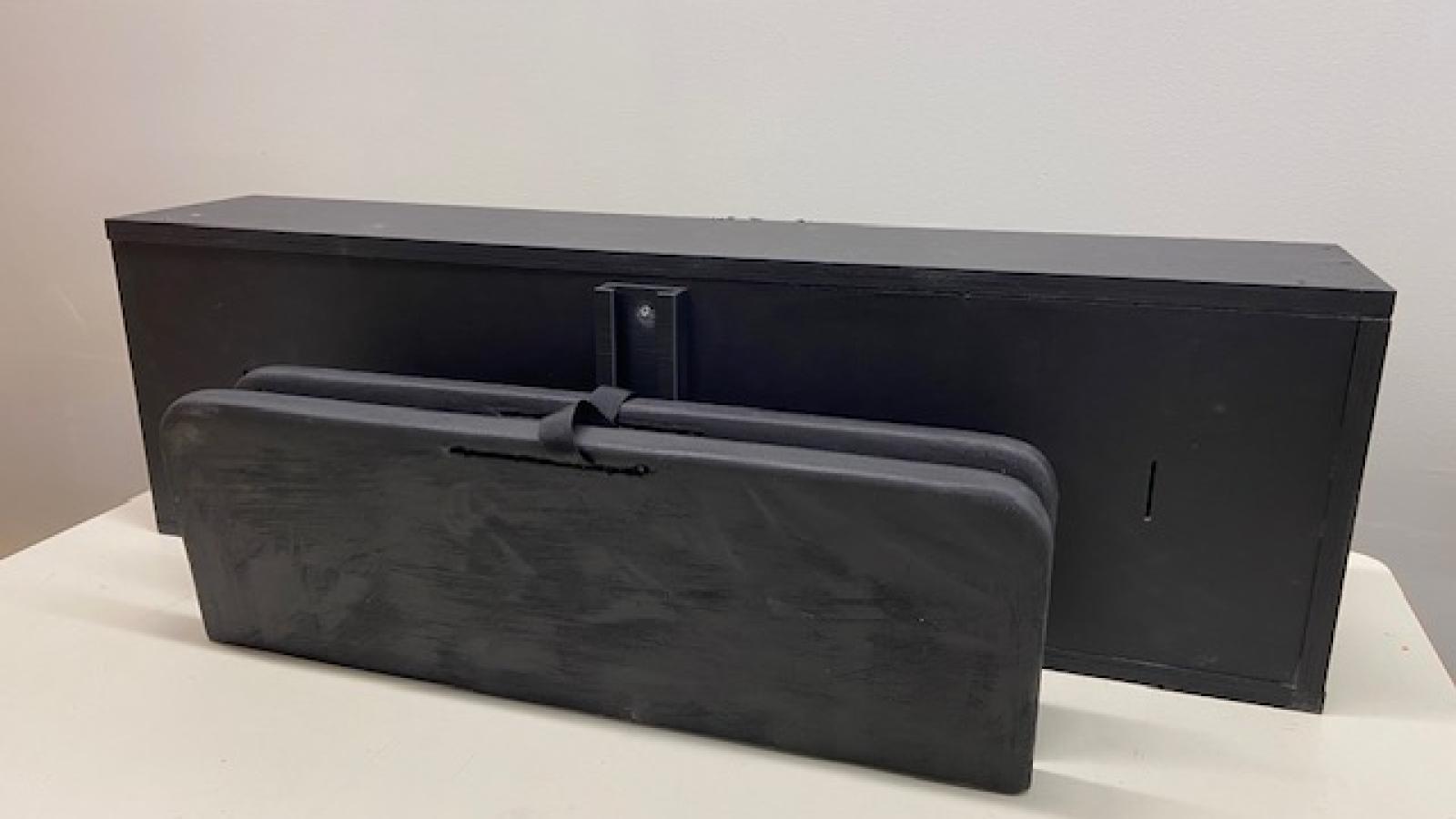 The prototype is folded against the back wall of the frunk, bent at the hinges in the center of the table.