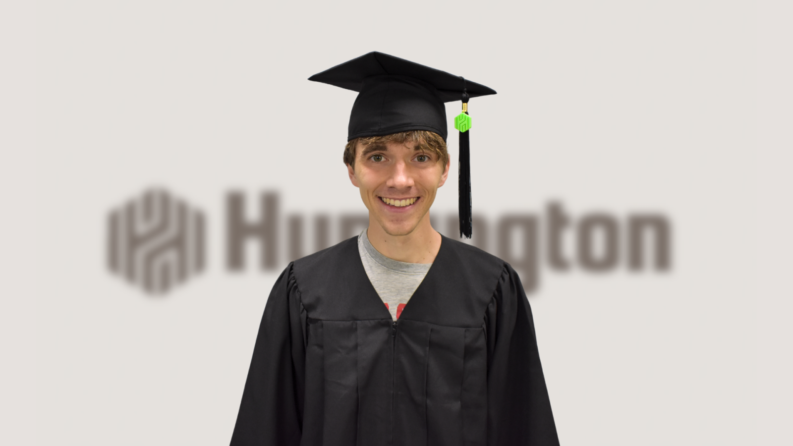 5.	An image of a Cross Country athlete at The Ohio State University wearing a graduation cap and gown with a Huntington branded tassel. In the background is the Huntington logo blurred out. 