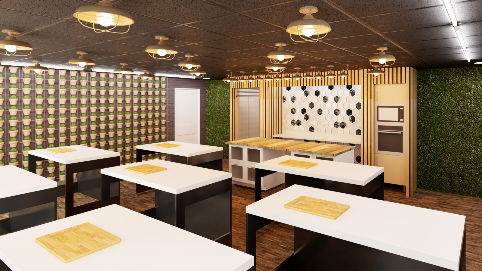 A modern teaching kitchen with multiple black and white workstations, each equipped with a wooden cutting board. The room features warm lighting, a hexagonal tile backsplash, a built-in oven, and green vertical garden walls. The left wall is lined with small potted plants, adding a biophilic design element.